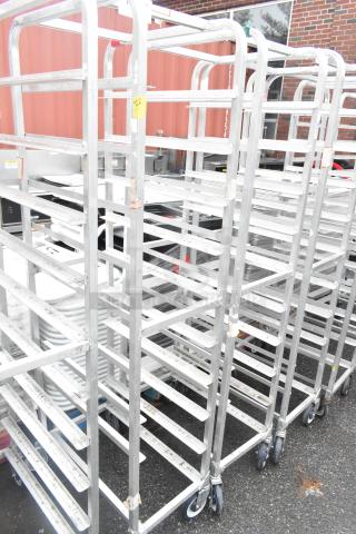 Winholt metal commercial pan transport racks on casters, durable frame, multiple shelves, suitable for bakery or kitchen use.