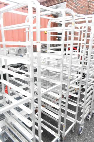 2 Winholt metal commercial pan transport racks on casters, sturdy and ideal for bakery or kitchen use.