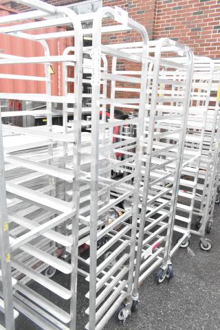 Two Winholt metal commercial pan transport racks on casters, used, durable construction. Tags indicate "CAKE RACK."
