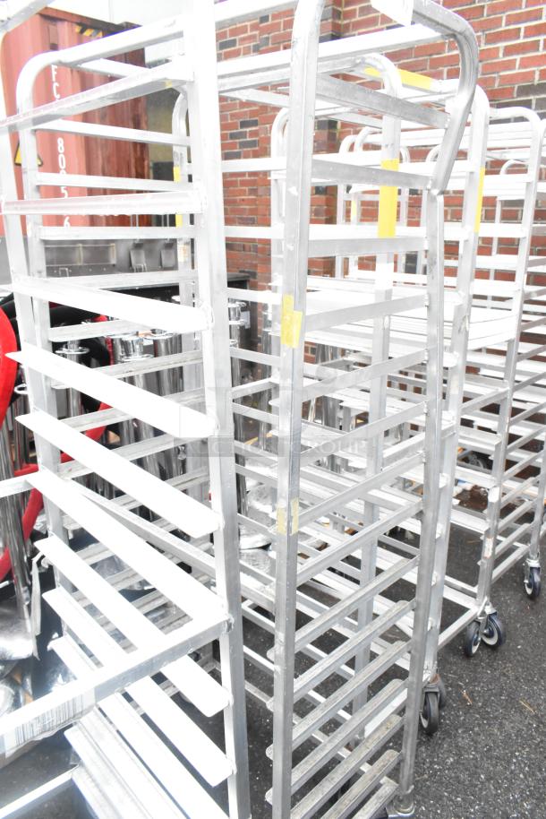 Winholt metal commercial pan transport rack with multiple shelves on heavy-duty casters, showing robust, used condition.