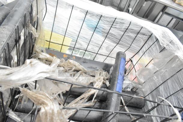 Pallet lot of various items including black poly pipes, wrapped in plastic, inside a metal wire container.