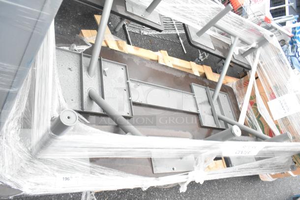 Industrial-style metal table, assembled, upside down for packaging. Sturdy legs, wrapped for protection. Appears new.