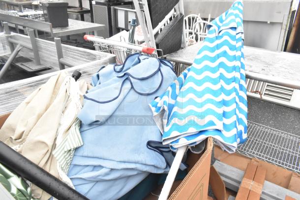 Pallet lot of various items including blue and striped patio umbrellas, beige fabric, and metal locker parts in used condition.