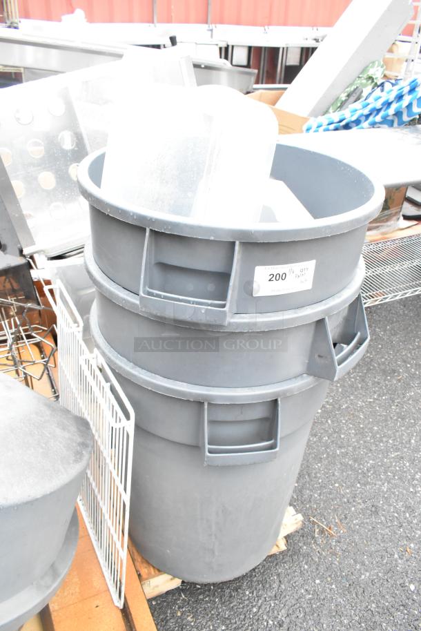 Pallet with gray poly trash cans and lids, folding table. Label indicates quantity: 200.