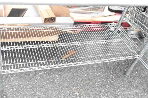 Stainless steel table with chrome finish wire under shelf, used condition, ideal for storage or workspace.