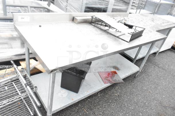 Stainless steel commercial table with single bay sink, metal under shelf, and slight wear; ideal for industrial kitchens.