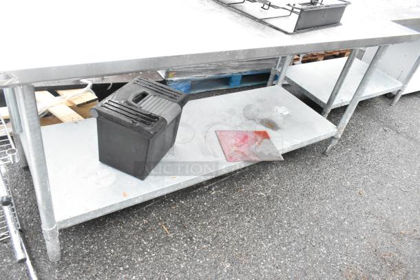 Stainless steel commercial table with single bay sink, metal under shelf, black container, and red cutting board.