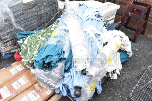 Pallet of assorted items including colorful patio umbrellas, some wrapped in plastic. Visible labels and packaging intact.