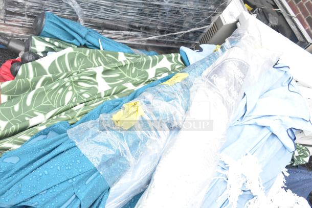 Pallet lot of assorted items including colorful patio umbrellas. Items are packed together, showing diverse patterns and colors.