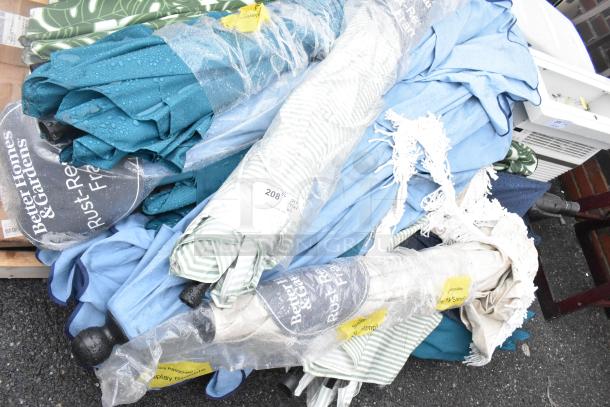 Pallet lot with various items, featuring Better Homes & Gardens patio umbrellas in assorted colors, wrapped in protective plastic.