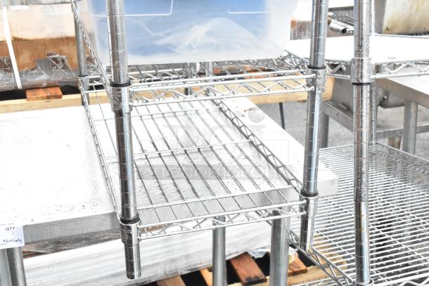 Stainless steel table with metal under shelf, wire shelving unit on top, in good condition.