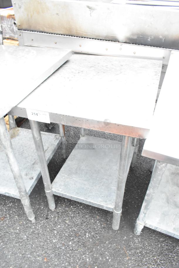 Stainless steel table with metal under shelf, showing signs of use. Features visible label "214" on the edge.
