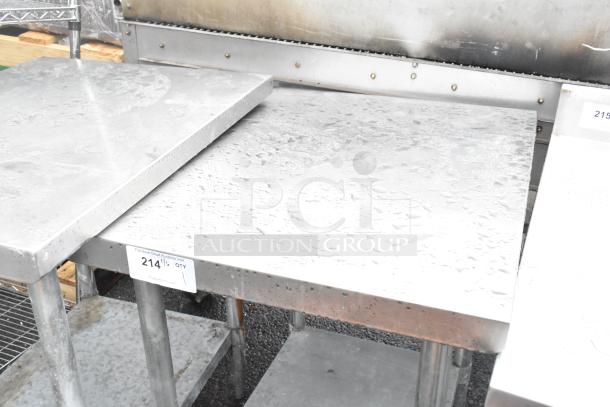 Stainless steel table with metal under shelf, displaying wear. Label showing auction details. Ideal for industrial use.