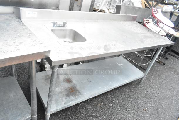 Stainless steel table with a single bay sink, metal under shelf, and visible tap fittings, slight surface wear.