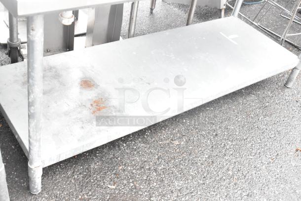 Stainless steel table with single bay sink and metal under shelf. Surface exhibits rust and wear. Ideal for industrial use.