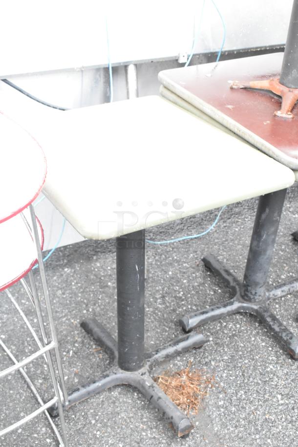 Four assorted tables, three dining height and one bar height, with metal bases. Visible wear, ideal for indoor or outdoor use.