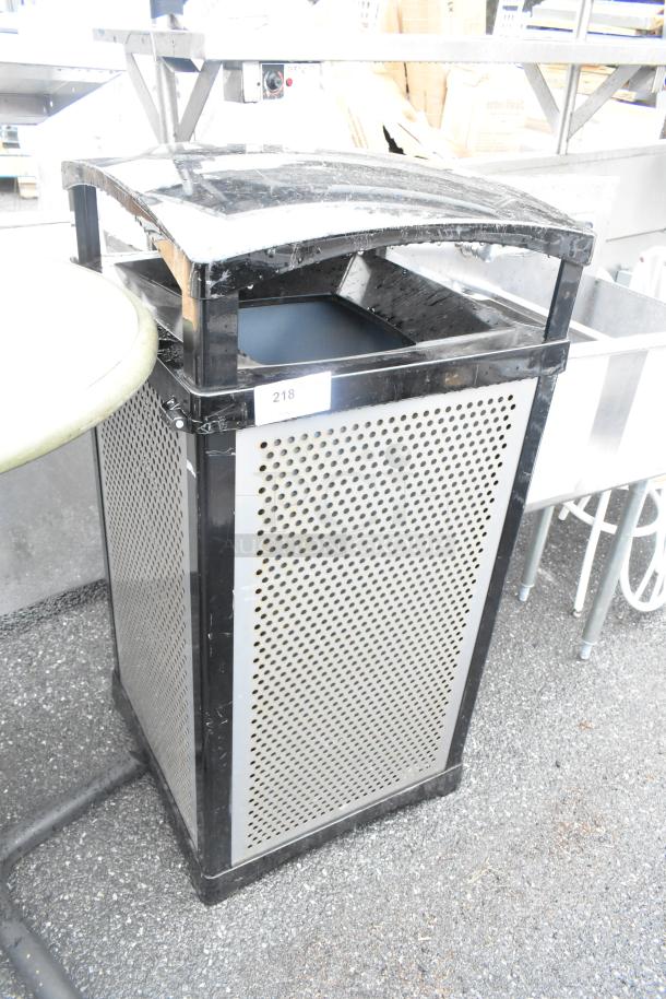 Rubbermaid black metal trash can shell with perforated sides. Prominent top opening, minor wear. Label marked "218" visible.
