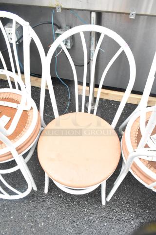 Set of six white dining height chairs with metal frames and circular wooden seats. Used condition with visible wear.