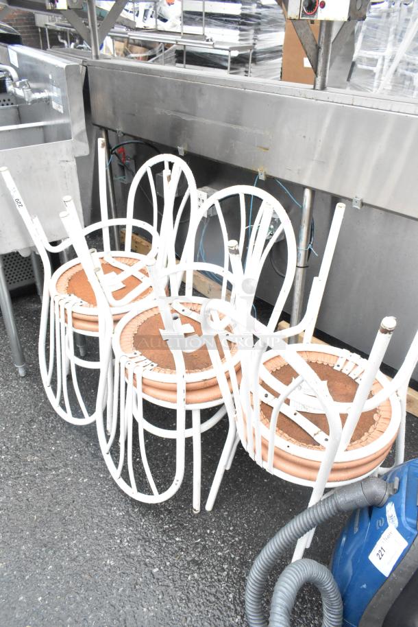 6 white dining height chairs stacked, metal frames, visible wear, brown cushioned seats, auction tags attached.