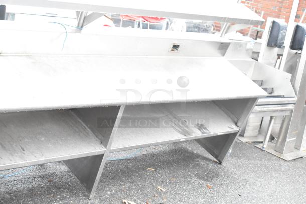 Stainless steel commercial table with 2 food strip warmers, under shelves, and over shelves. Used condition.