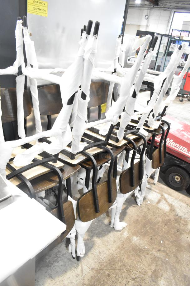 Eight black metal bar height chairs with wooden seats and backrests, brand new, wrapped in protective material.