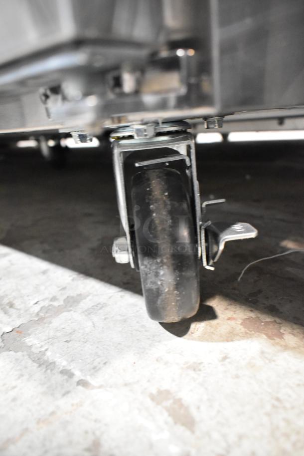 Close-up of a caster wheel on an Avantco 178APT71MHC commercial prep table, showcasing its mobility feature.