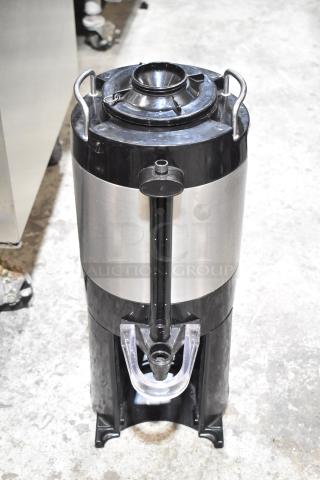 Fetco Stainless Steel Beverage Holder Dispenser, cylindrical design, black and silver finish, with spout and carrying handles.