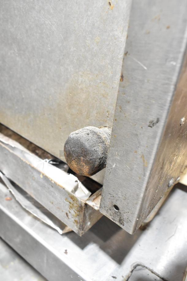 Vulcan stainless steel charbroiler grill close-up showing heavy wear; natural gas powered; on equipment stand with casters.