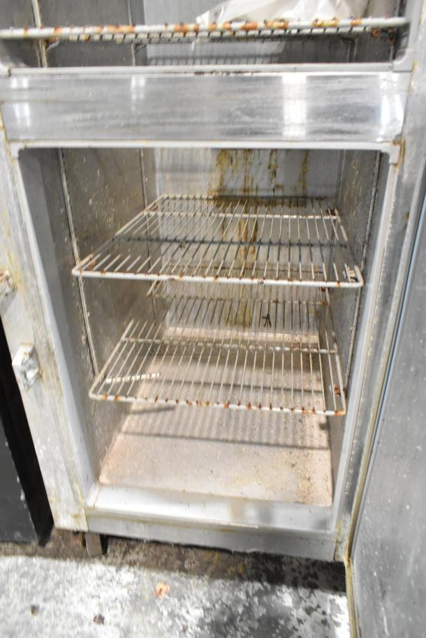 Continental 1R-HD stainless steel reach-in cooler, two half-size doors, commercial casters, visible wear, model 1R-HD.