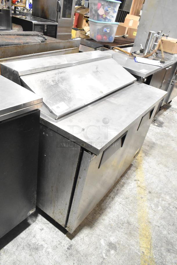 True TSSU-48-12 stainless steel prep table, commercial casters, 115V, 1 phase. Used condition with visible wear.