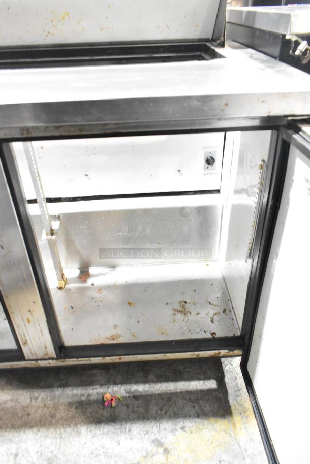 True TSSU-48-12 stainless steel prep table with bain marie top, commercial casters, showing interior storage. Needs cleaning.
