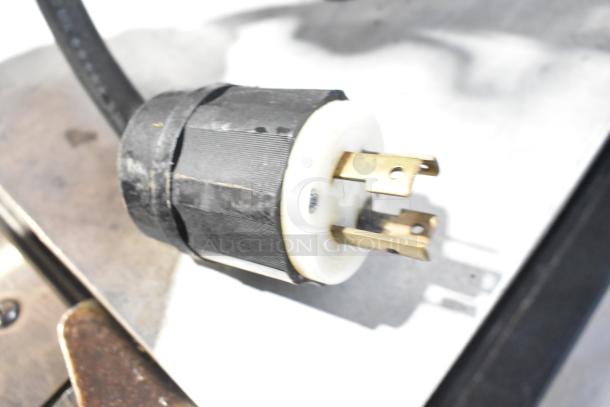 Close-up of a 3-prong plug for the 2016 Bunn DUAL SH commercial coffee machine, indicating power compatibility.