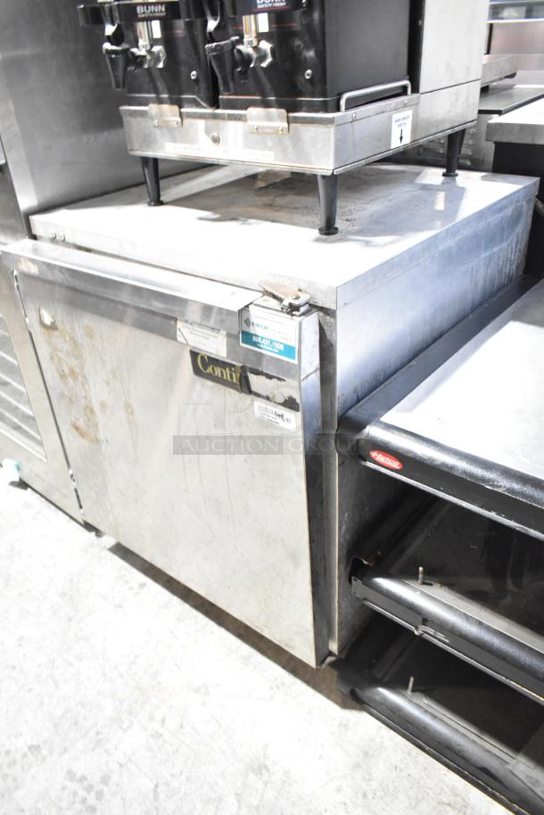 Continental UR27 stainless steel undercounter cooler, single door, on commercial casters, visible wear, 115 volts, 1 phase.