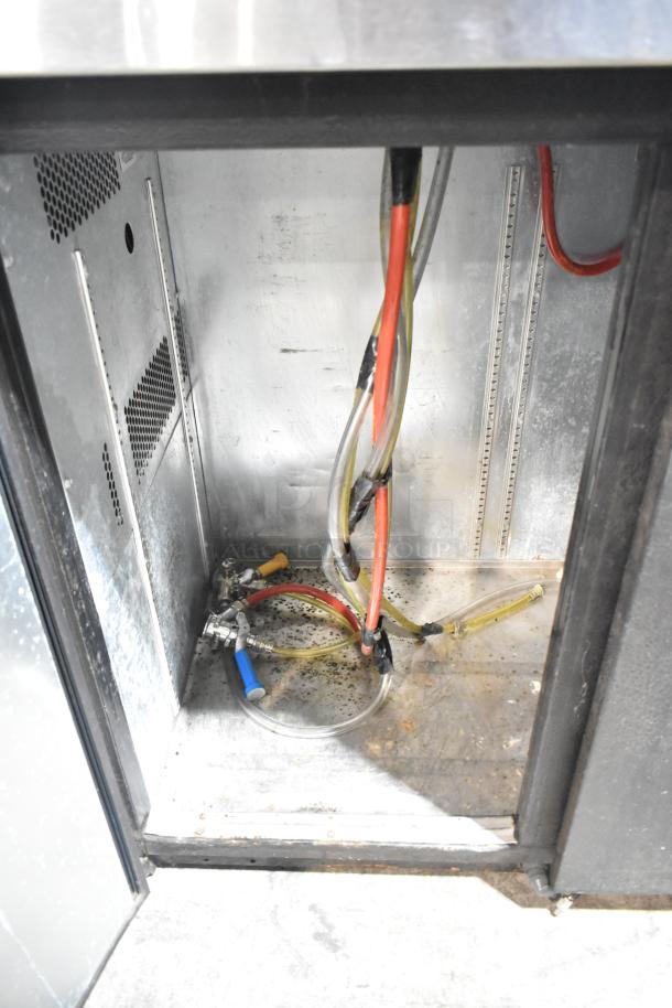True TDB-24-48 kegerator interior, showing beer lines and taps. Metal construction, uses 115 volts, 1 phase.