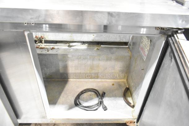 Continental BW60-16 stainless steel prep table interior showing power cord and some wear. Model, voltage, and phase labeling visible.