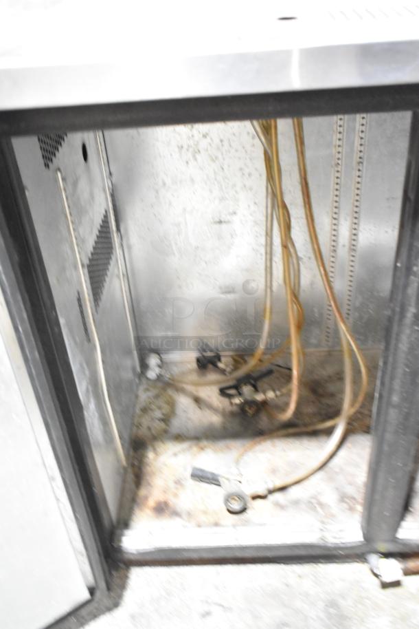 True TDB-24-48 metal kegerator interior showing taps, tubing, and metal surfaces. Condition appears well-used.