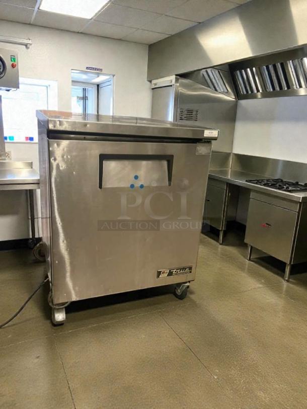 True TUC-27-LP undercounter refrigerator, stainless steel, 115V, fully tested, True Manufacturing label, on casters.