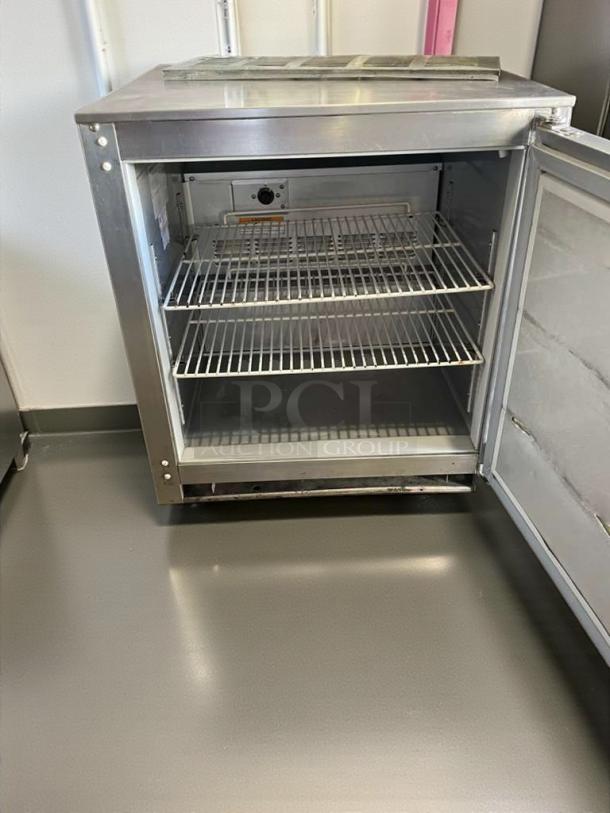 Beverage-Air UCR27A undercounter refrigerator, stainless steel, double wire shelves, open door, excellent condition.
