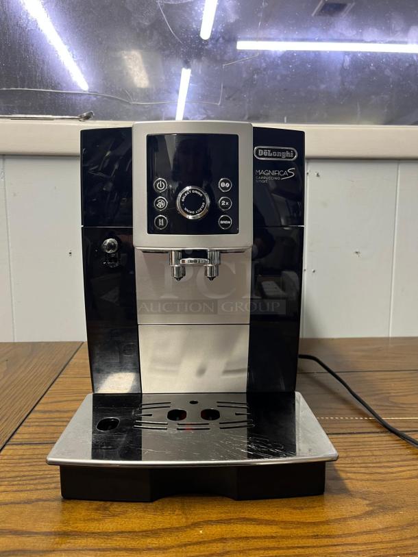 De'Longhi Magnifica S espresso machine with built-in grinder, black-silver finish, front control panel, used condition.