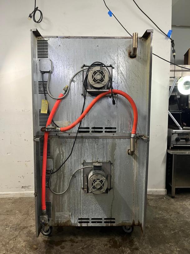 Rear view of an IMPERIAL DOUBLE DECK convection oven showing electrical and exhaust components. Signs of use visible.