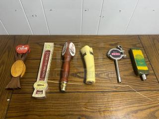 Assorted tap handles in various designs, brands include Embark Craft and Cigar City Brewing, in good condition.