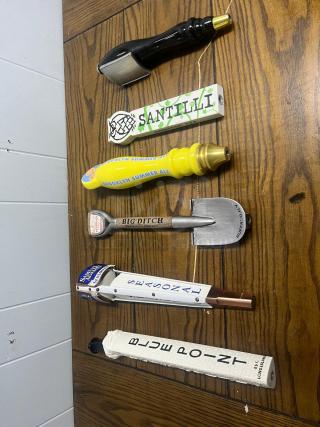 Assorted tap handles featuring various brands like Santilli, Brooklyn Summer Ale, Big Ditch, and Blue Point.