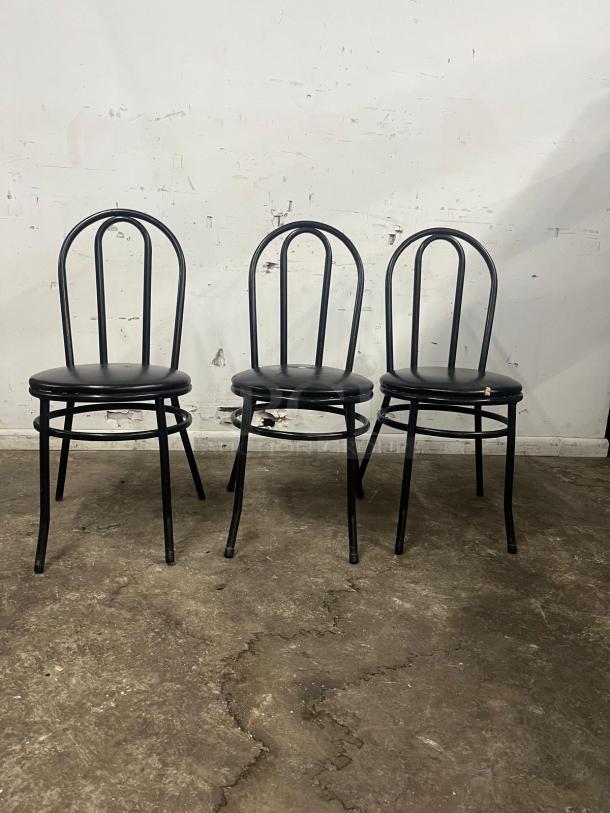 Cafe dining chairs with black metal frames and padded vinyl seats. Set of three; good condition with minimal wear.