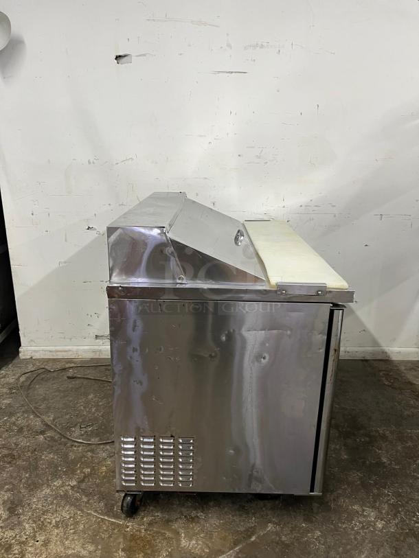 Turbo Air MST-48 M3 Series 48in sandwich prep table, stainless steel, visible wear, on casters, closed lid.