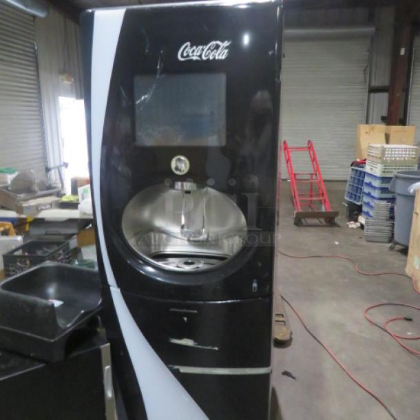 Pininfarina FREESTYLE soda dispenser, black, Coca-Cola branding, 25x35x75 inches, moderate wear, touchscreen interface.