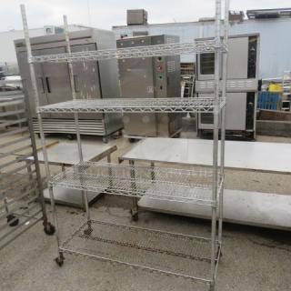 Metro shelf with 4 wire shelves, 48x18x76 inches, on casters. Sturdy condition, ideal for storage.