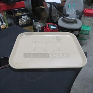 Beige 18x14 plastic lunch tray on a table, showing slight wear. Ideal for cafeterias or restaurants.