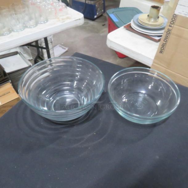 Assorted glass mixing bowls, set of two. Clear glass; different sizes. Excellent condition. Smooth, rounded edges.
