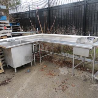 Stainless steel work table with handsink 10x14x8 and large deep sink 28x28x28, both with faucets. Dimensions 81x105x40.5. Potential outdoor element exposure.