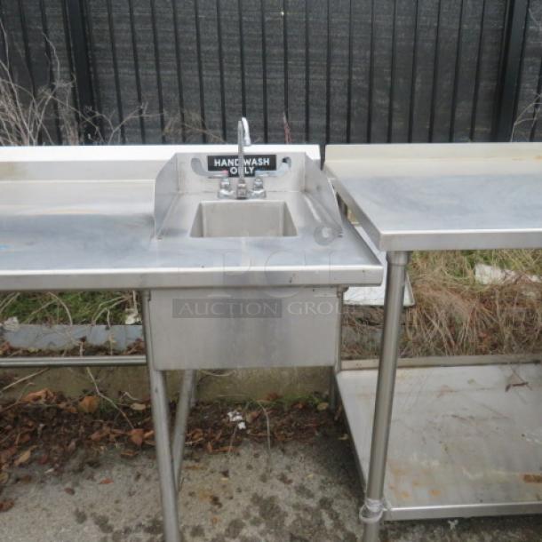 Stainless steel work table with 10x14x8 hand sink, faucet, and large 28x28x28 deep sink. Dimensions: 81x105x40.5.
